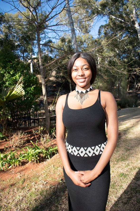 Young African lady wearing a matching beaded necklace and belt.